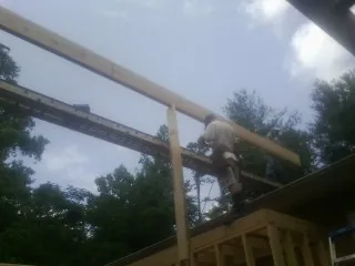 Carpenter setting a ridge beam over a new addition frame — Ice Dam Removal by Roofing Brothers in Hornbeak