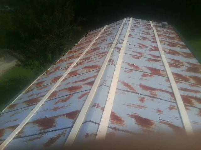 Rusted metal roof panels with new wood purlins before replacement — Storm Damage Roof Repair in Hornbeak by Roofing Brothers