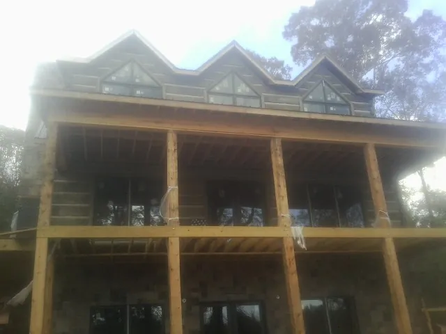 Dormers and porch framing on a large log home under construction — Roof Coating work by our crew in Hornbeak