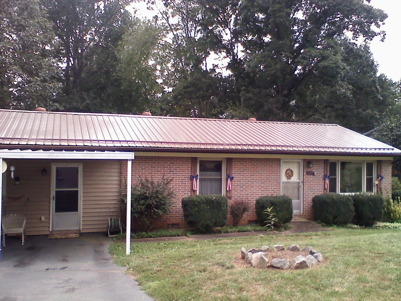 Bronze metal roof and carport on a brick ranch home — Roof Repair work by our crew in Hornbeak